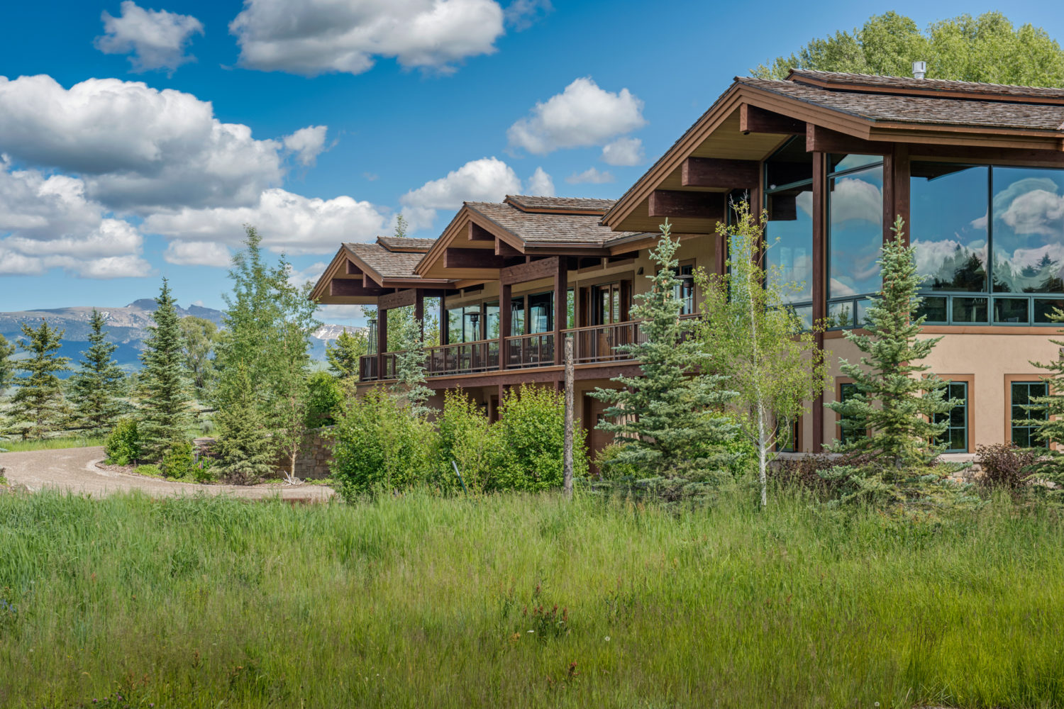 gate_house_outside A beautiful home with large windows overlooking trees and grassy lawn