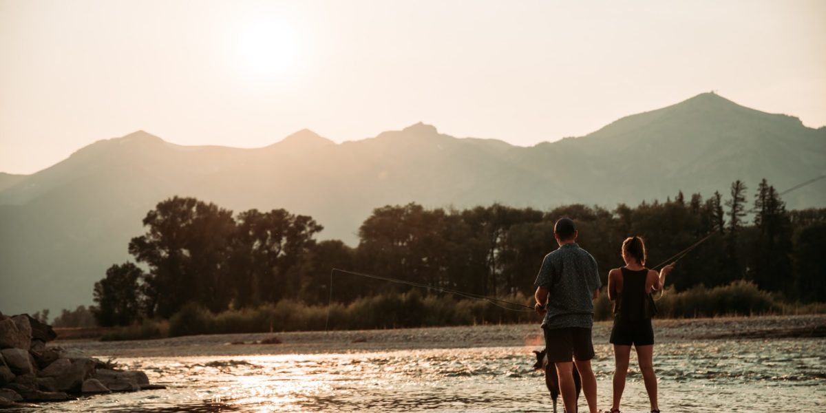 couple_fishing A man and woman fly fish on the river during sunset